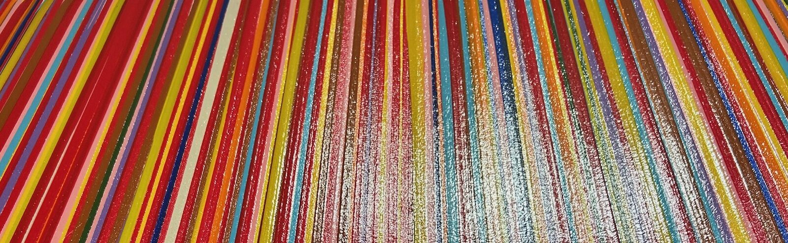 A close-up view of the brightly colored stripes of a painting by Jun Kaneko